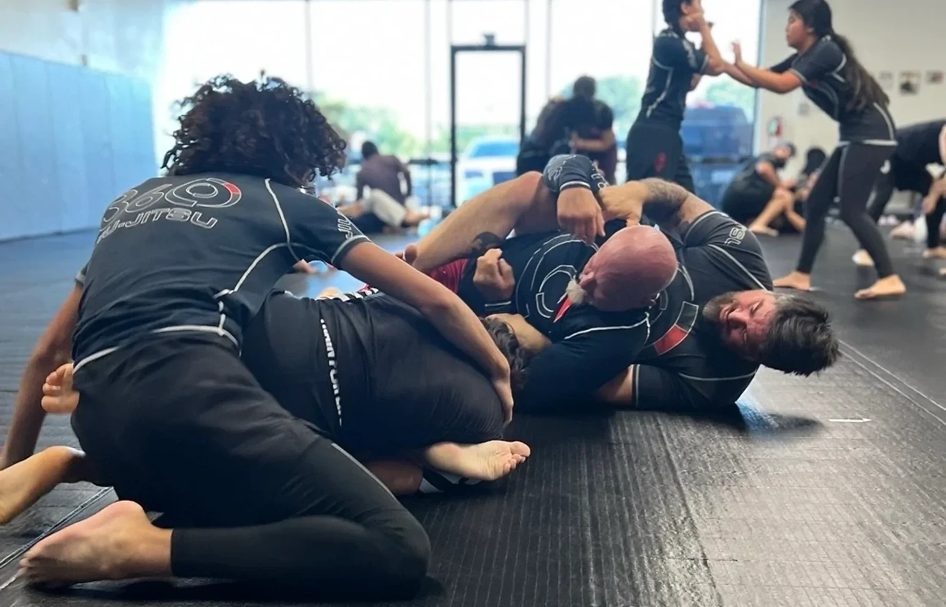 Adults rolling on the mat at 360 Jiu-Jitsu